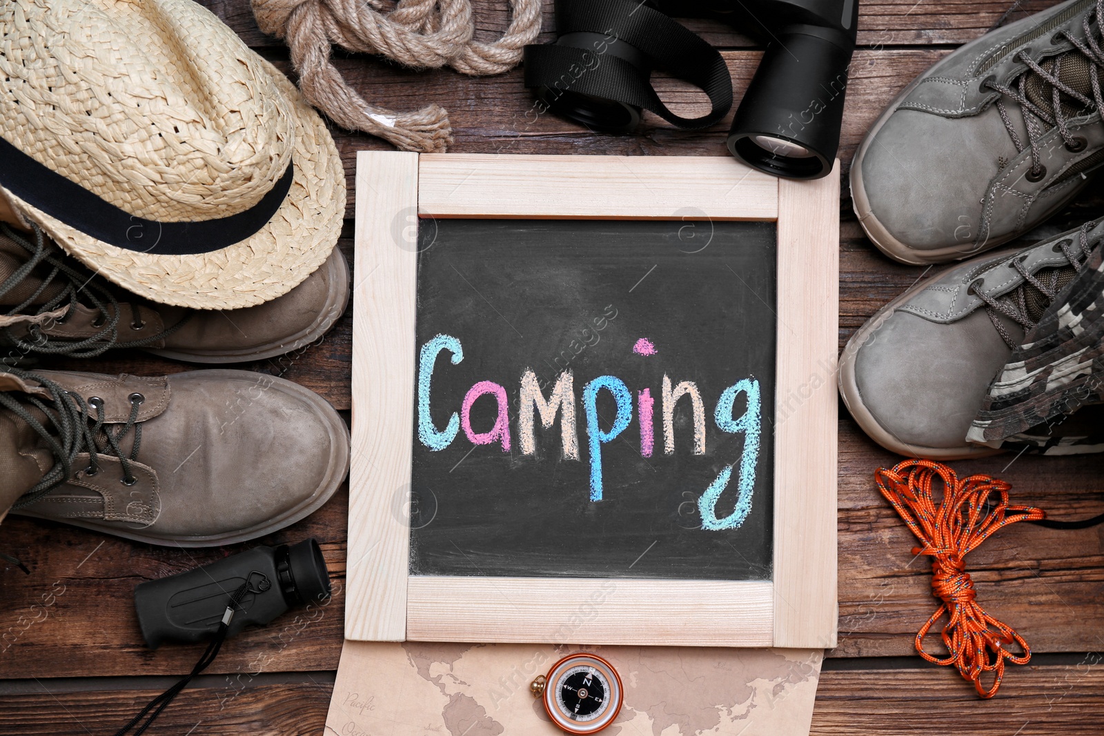 Photo of Flat lay composition with camping equipment on wooden background