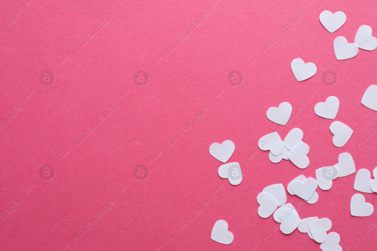 Photo of White paper hearts on pink background, flat lay. Space for text