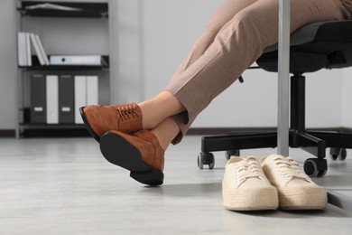 Comfortable sneakers near businesswoman in elegant shoes indoors, closeup