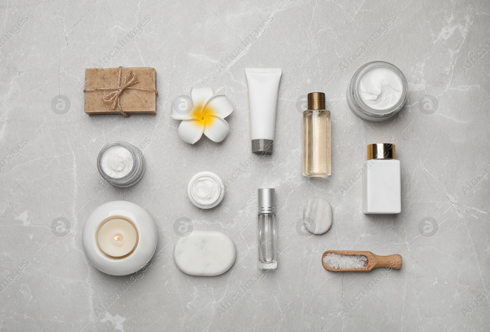 Photo of Flat lay composition with cosmetics and sea salt on grey marble table. Spa treatment