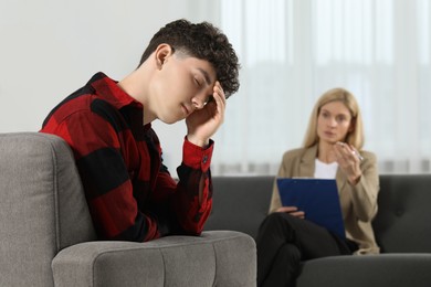 Psychologist working with teenage boy in office. Teenager problems