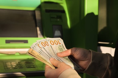 Man with money near cash machine, closeup