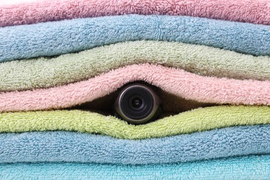 Photo of Camera hidden between folded towels, closeup view