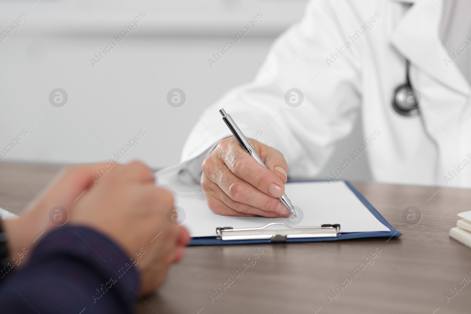 Photo of Patient having appointment with senior doctor in clinic, closeup