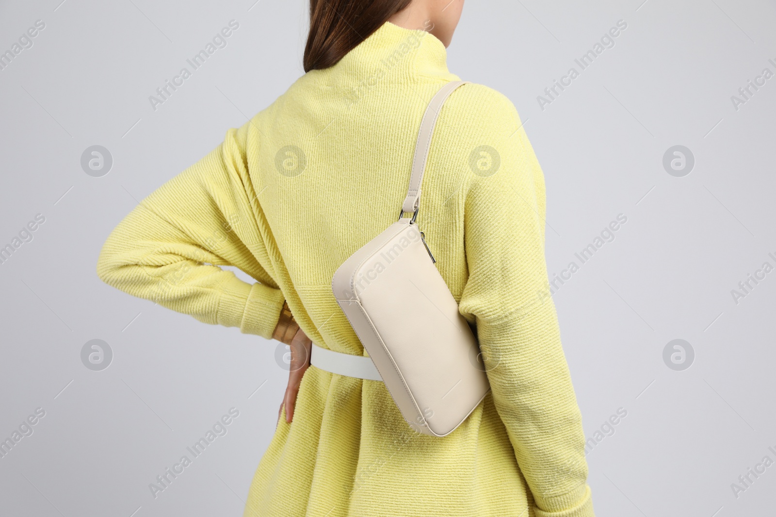 Photo of Fashionable woman with stylish bag on light background, closeup