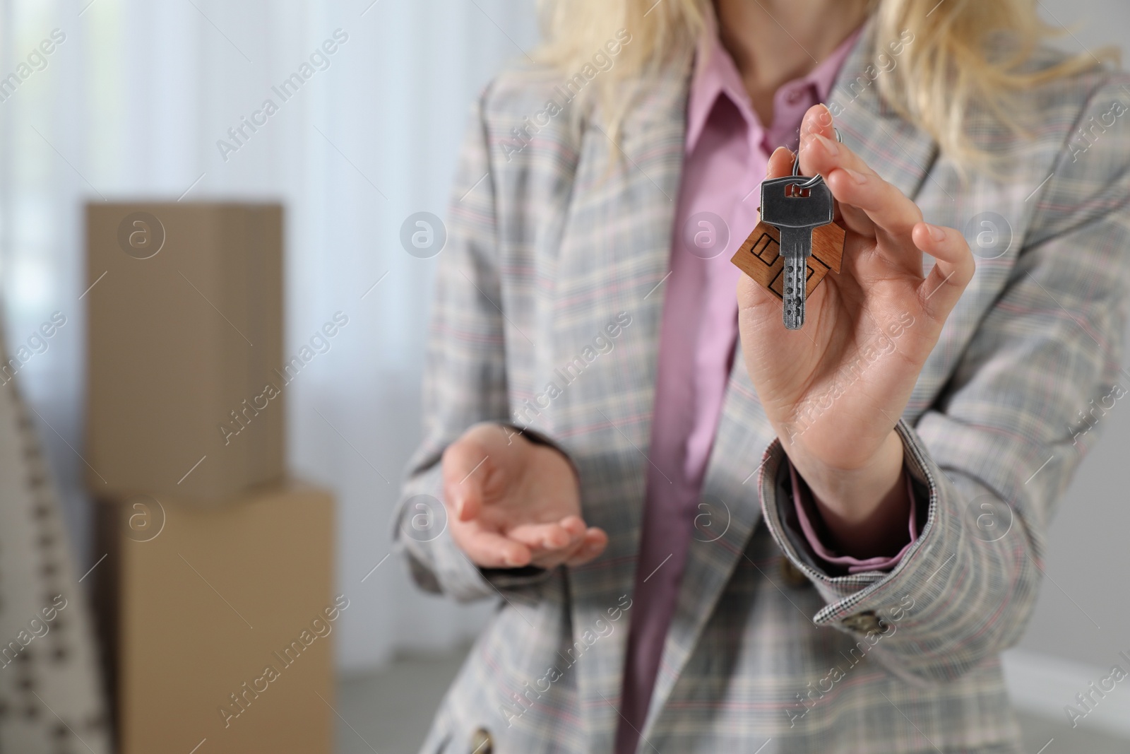 Photo of Real estate agent holding key in new house, closeup. Space for text