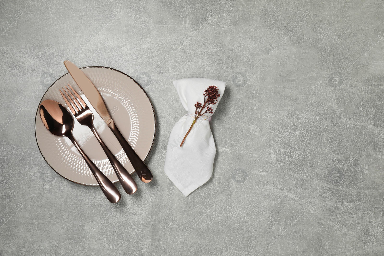 Photo of Stylish setting with elegant cutlery on grey table, top view. Space for text