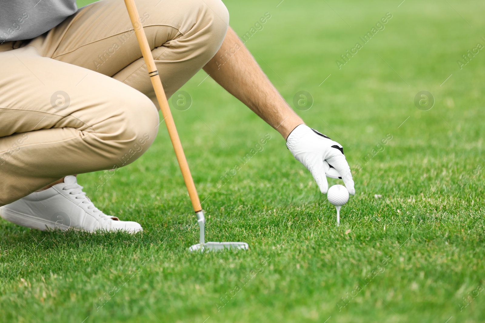 Photo of Man playing golf on green course. Sport and leisure