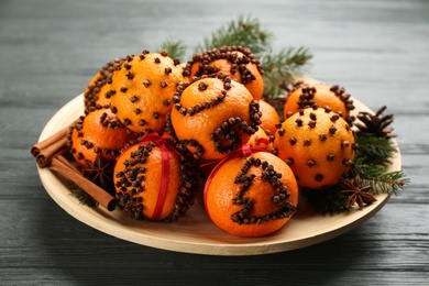 Pomander balls made of fresh tangerines and cloves on wooden table
