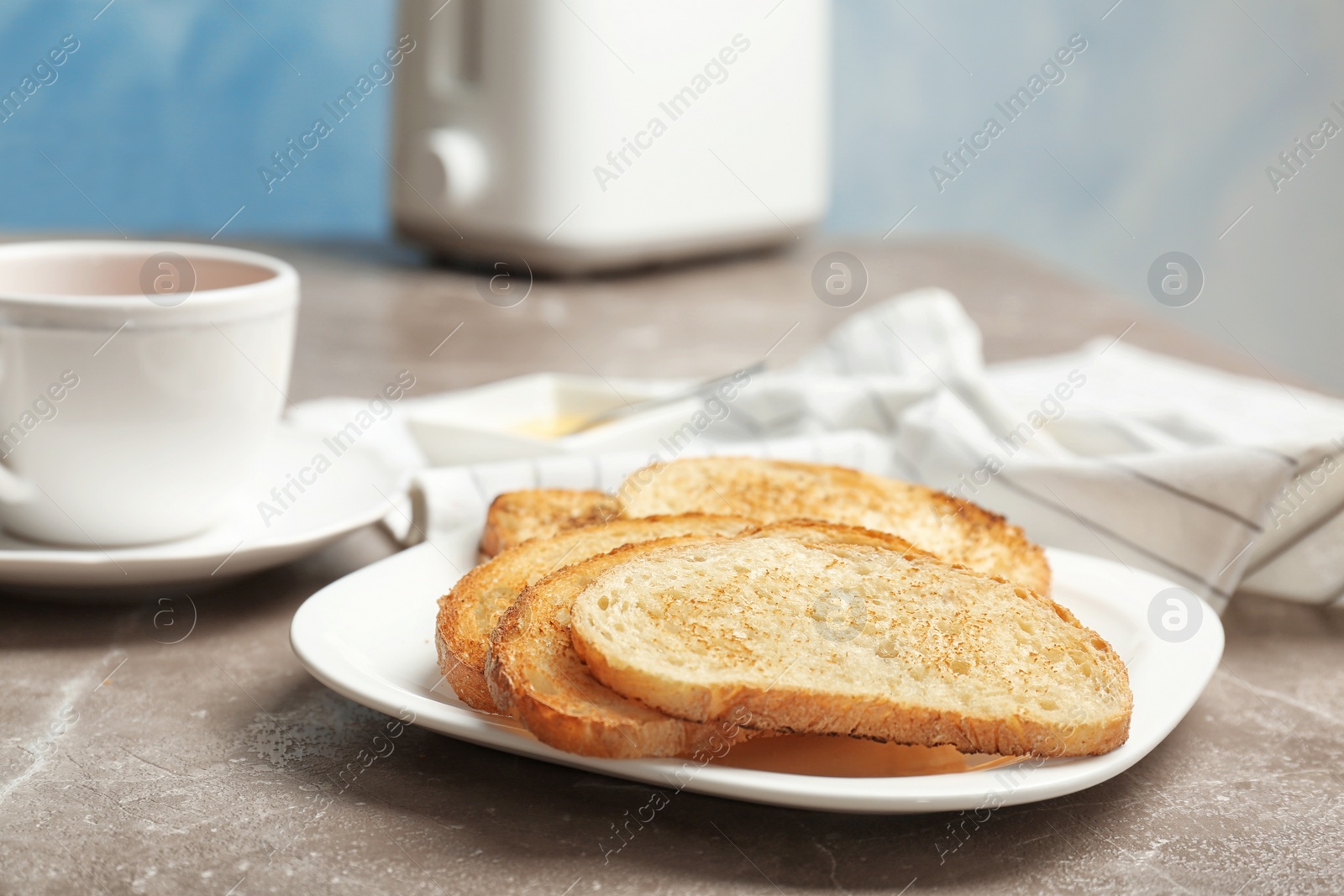 Photo of Plate with toasted bread on table