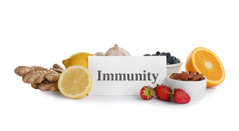 Photo of Set of natural products and paper with word Immunity on white background
