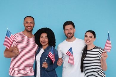 4th of July - Independence Day of USA. Happy friends with American flags on light blue background