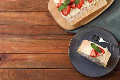 Photo of Delicious cake roll with strawberries and cream on wooden table, top view. Space for text