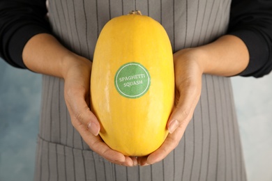 Photo of Woman holding spaghetti squash against color background, closeup