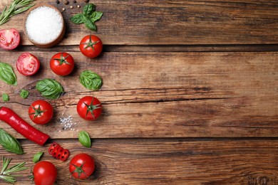 Flat lay composition with fresh green basil leaves on wooden table, space for text