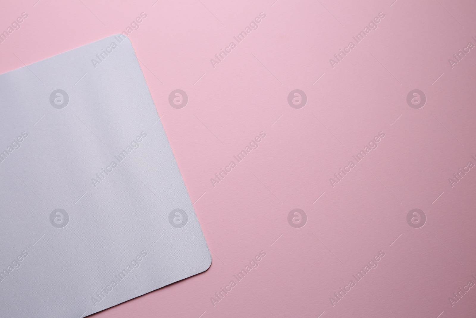 Photo of One mouse pad on pink background, top view. Space for text