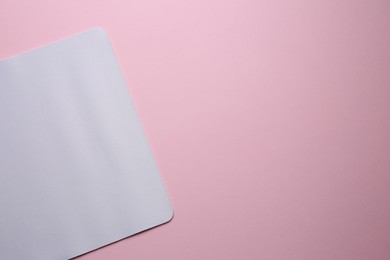 Photo of One mouse pad on pink background, top view. Space for text