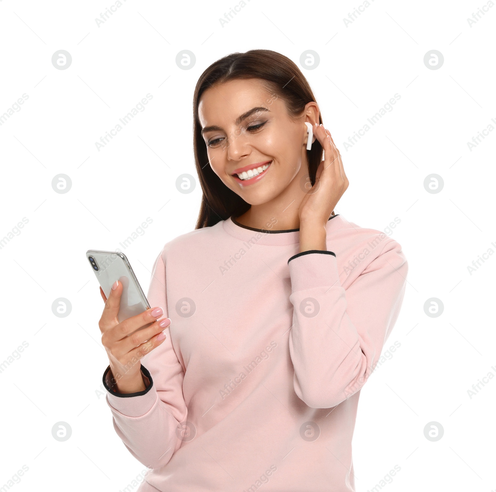 Photo of Happy young woman with smartphone listening to music through wireless earphones on white background