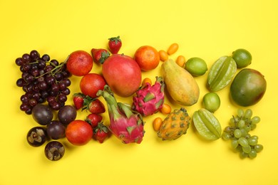 Photo of Assortment of fresh exotic fruits on yellow background, flat lay