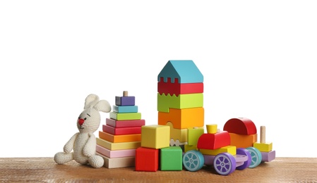 Set of different toys on wooden table against white background