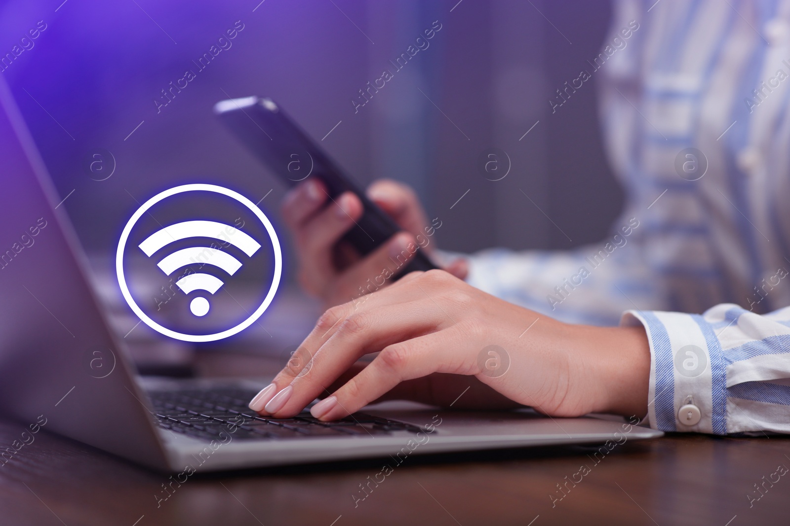 Image of Woman using smartphone and laptop connected to WiFi at wooden table indoors, closeup