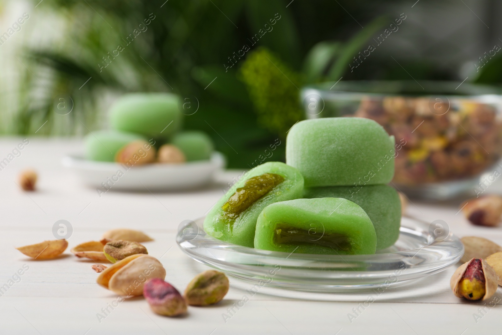 Photo of Delicious mochi and pistachios on white table. Traditional Japanese dessert