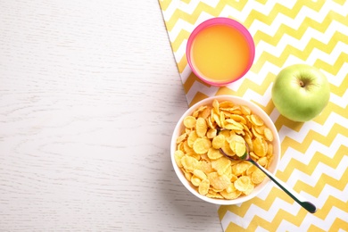 Flat lay composition with cornflakes on white wooden table, space for text. Healthy breakfast