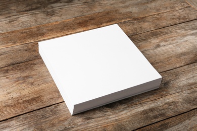 Photo of Stack of blank paper sheets for brochure on wooden background. Mock up