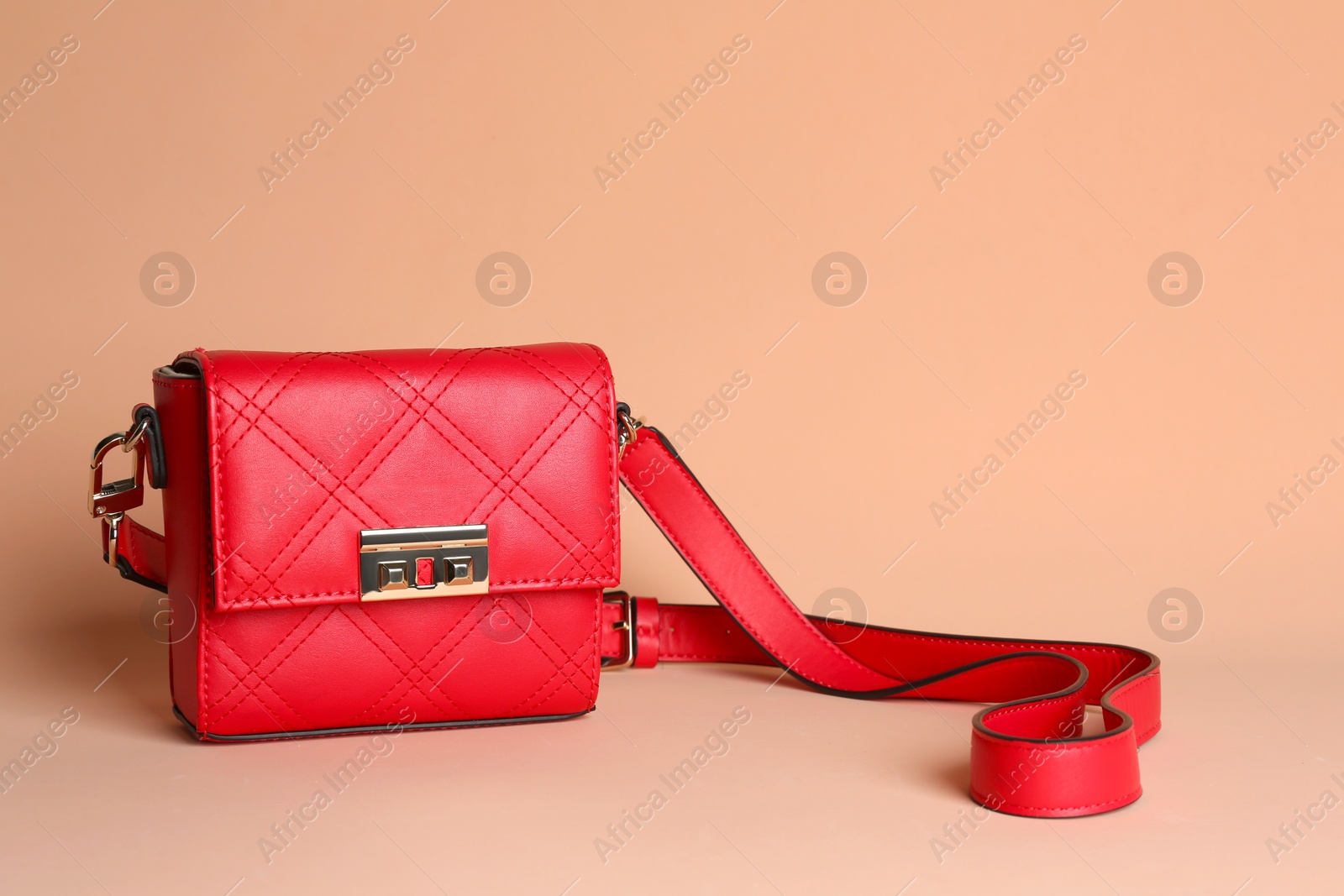 Photo of Red stylish woman's bag on pale pink background