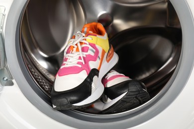 Photo of Different clean sneakers inside modern washing machine