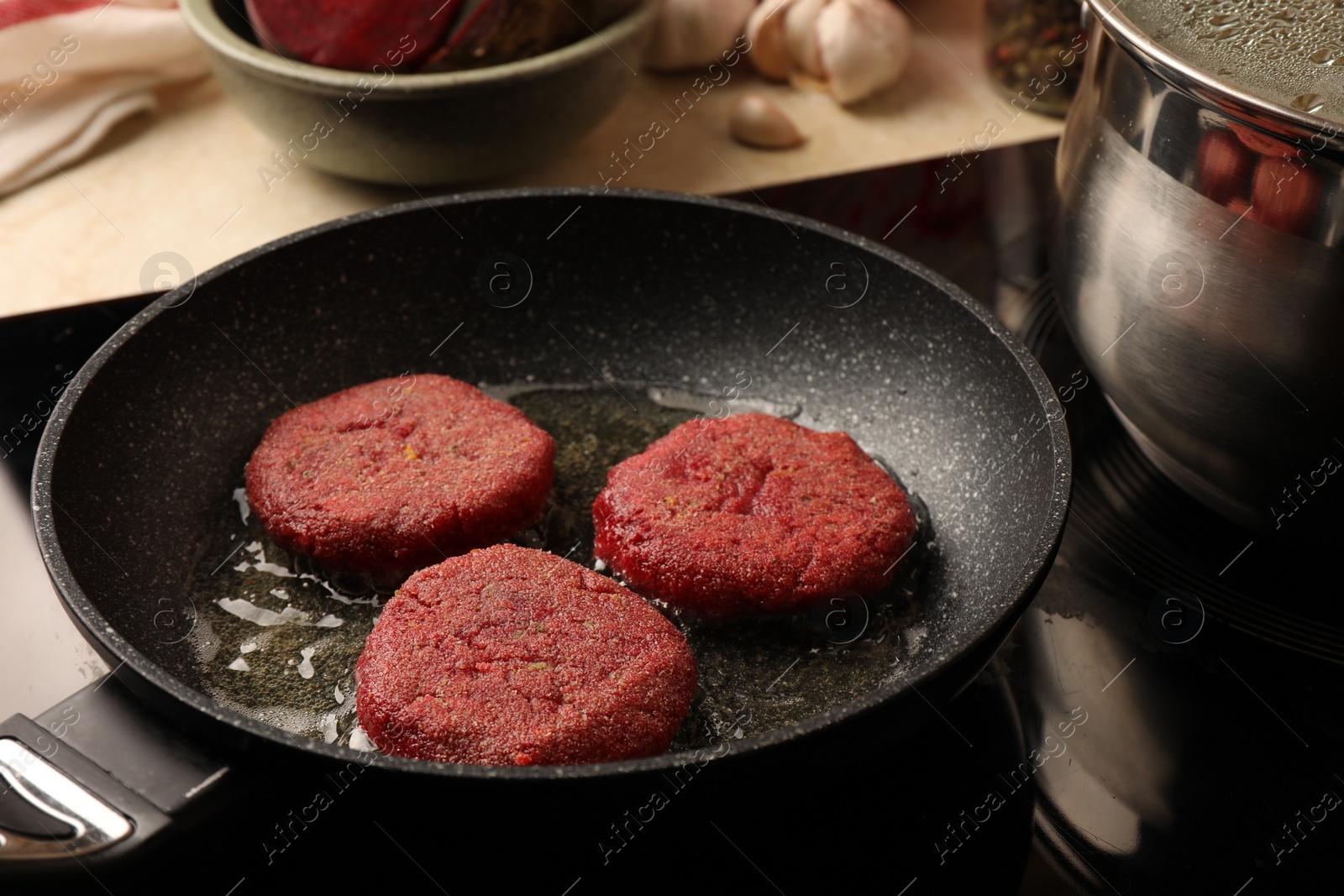 Photo of Cooking vegan cutlets in frying pan on stove, closeup