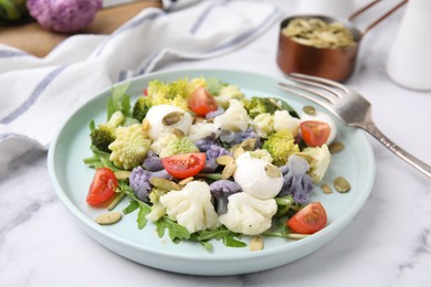 Delicious salad with cauliflower, tomato and cheese served on white marble table
