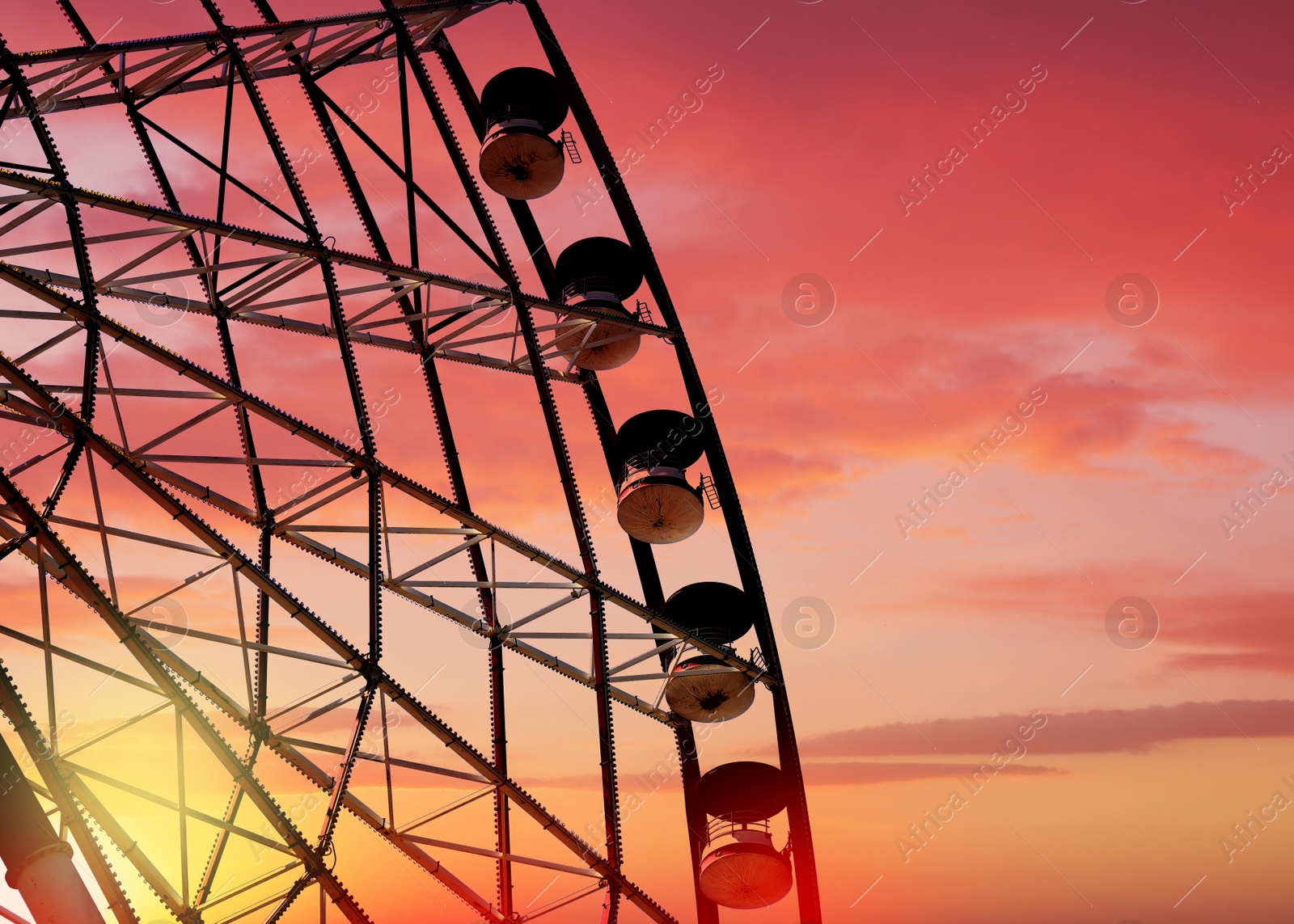 Image of Beautiful large Ferris wheel outdoors at sunset