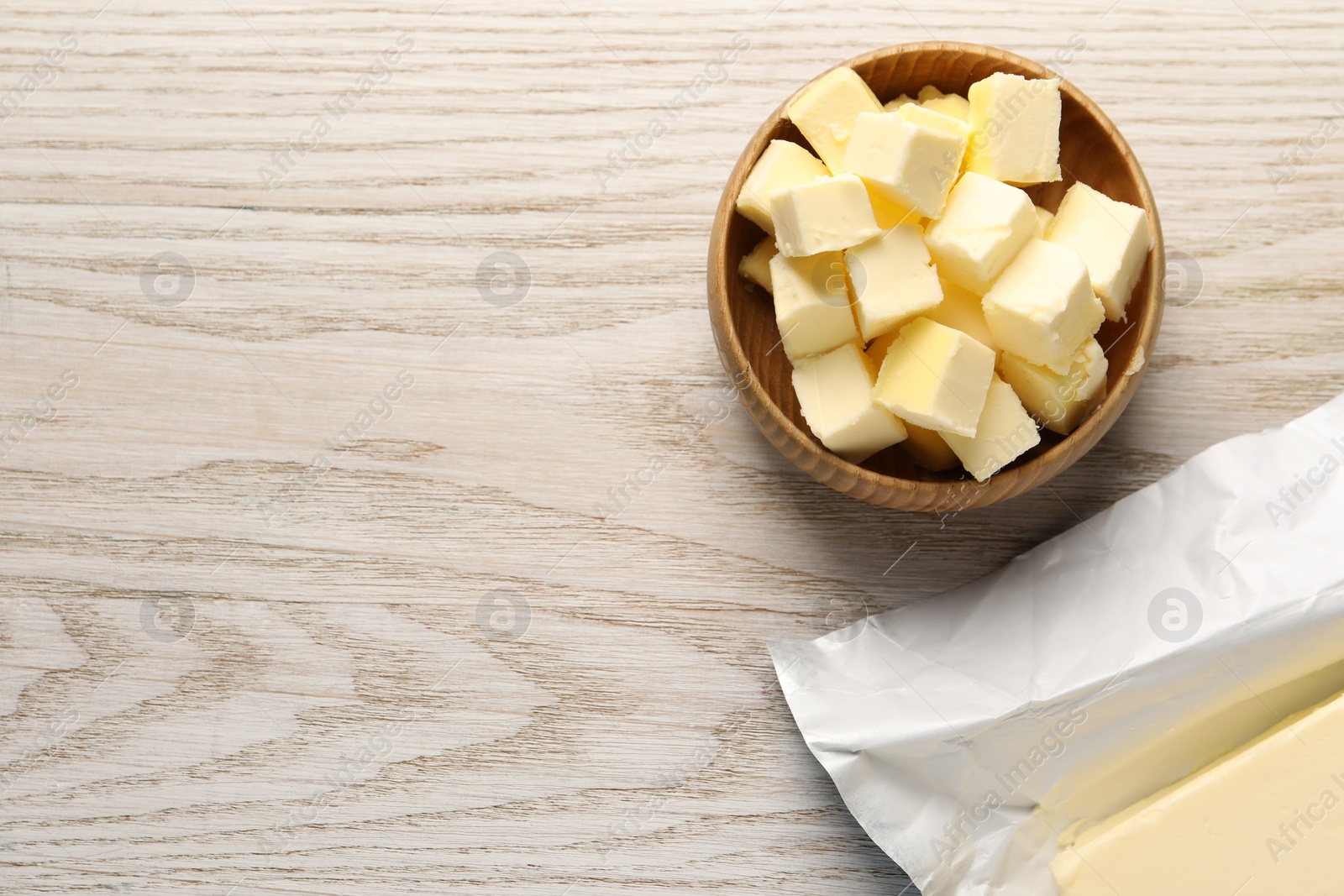 Photo of Tasty butter on light wooden table, flat lay. Space for text