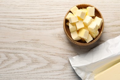 Tasty butter on light wooden table, flat lay. Space for text