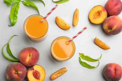 Photo of Natural freshly made peach juice on light table, flat lay
