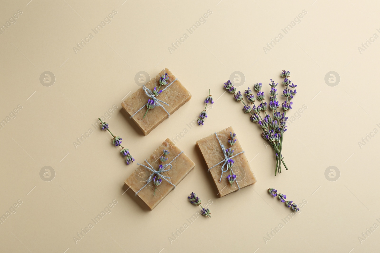 Photo of Flat lay composition of handmade soap bars with lavender flowers on beige background