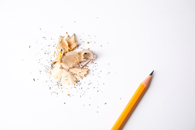 Photo of Pencil and shavings on white background, top view