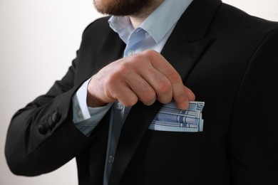 Photo of Man taking handkerchief from suit pocket on white background, closeup