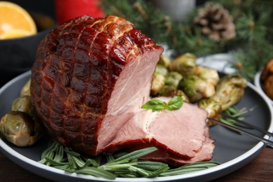 Photo of Delicious ham served with brussels sprouts and rosemary on table, closeup. Christmas dinner