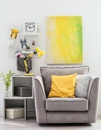 Photo of Room interior with modern desk lamp and comfortable armchair