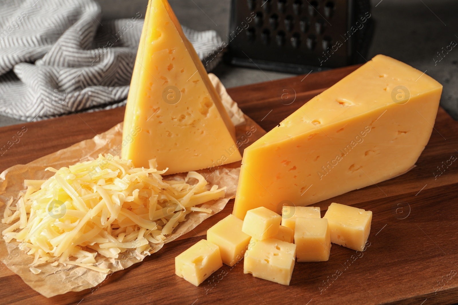 Photo of Grated and cut delicious cheese on board