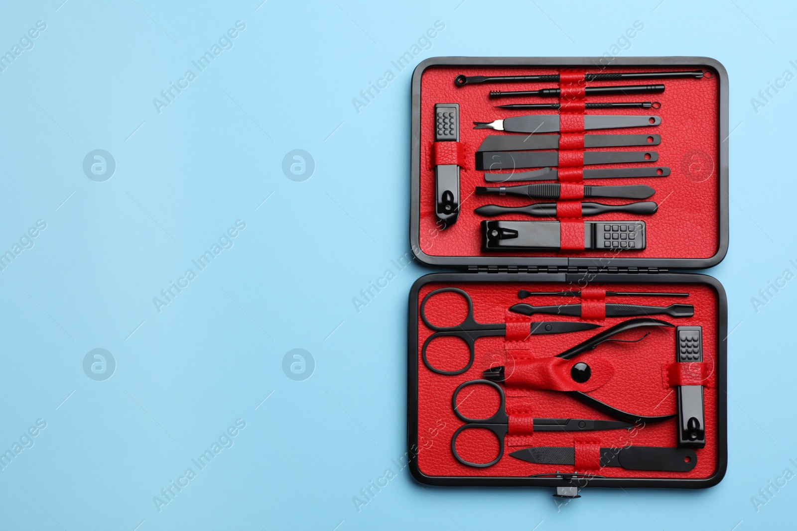 Photo of Manicure set in case on light blue background, top view. Space for text