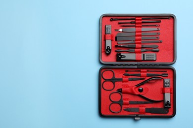 Manicure set in case on light blue background, top view. Space for text