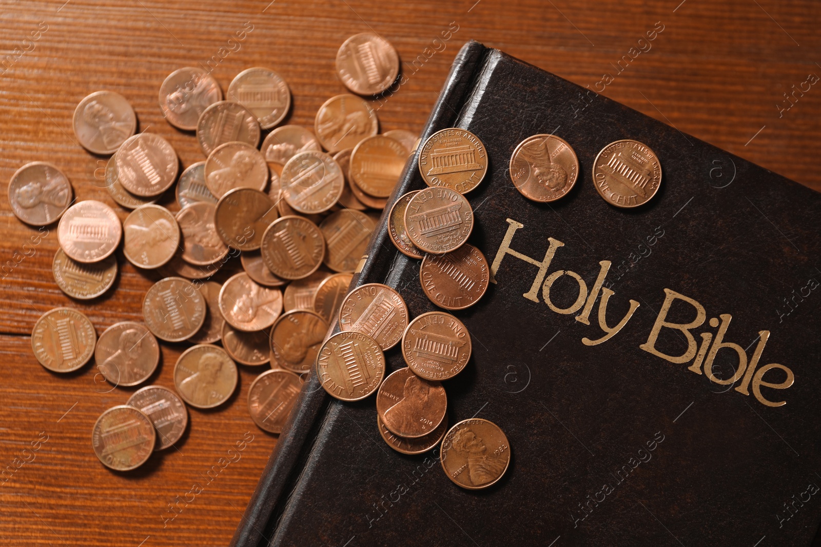 Photo of Donate and give concept. Coins and Bible on wooden table, flat lay
