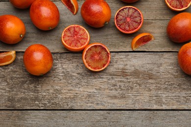 Many ripe sicilian oranges on wooden table, flat lay. Space for text