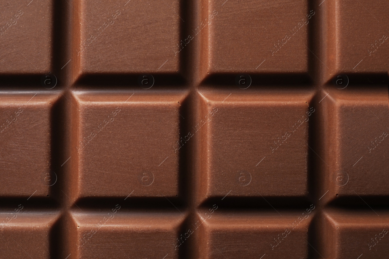 Photo of Delicious milk chocolate bar as background, top view