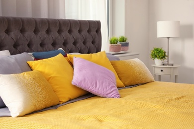 Photo of Different pillows on bed in room. Idea for interior decor