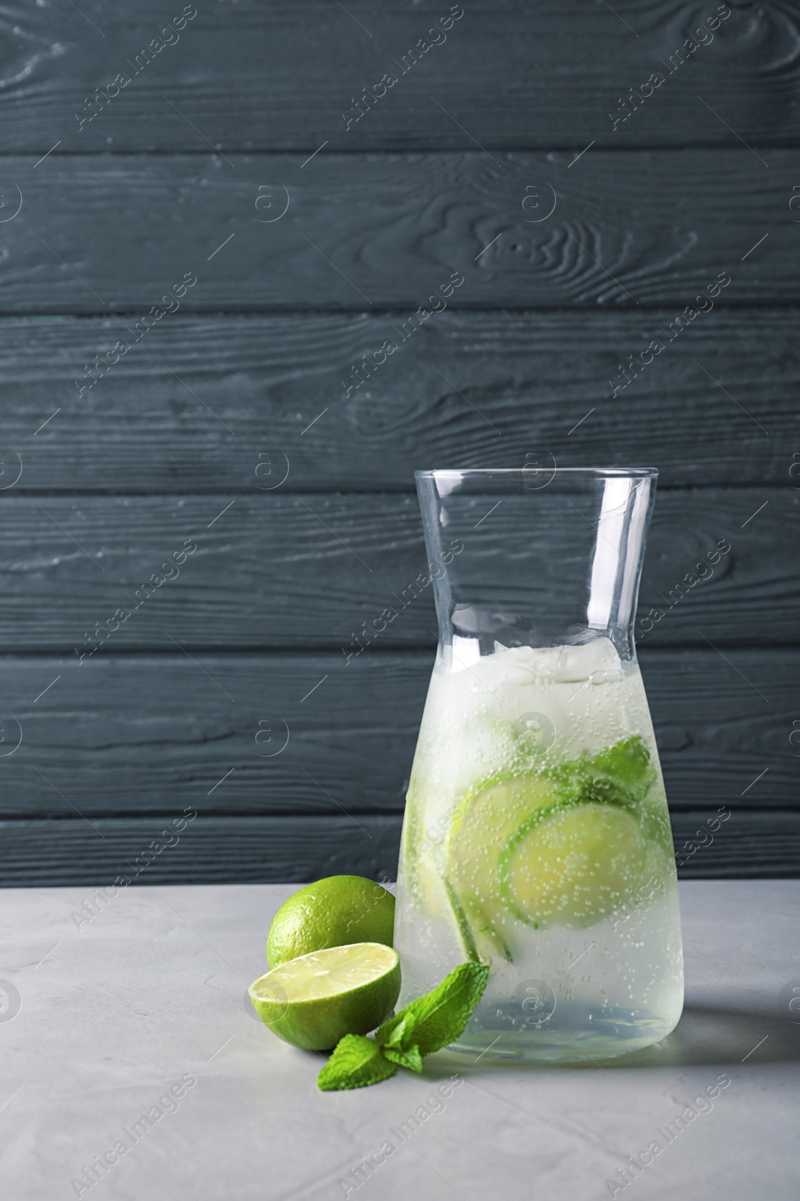 Photo of Natural lemonade with lime in jug on table