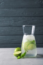 Photo of Natural lemonade with lime in jug on table